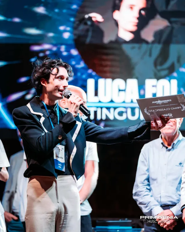 Luca Fol con il trofeo e il microfono — Finale Prima Edizione PMA 2025